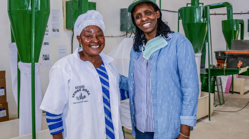 Dr. Kalibata poses for a photo with a female worker in an milling plant.