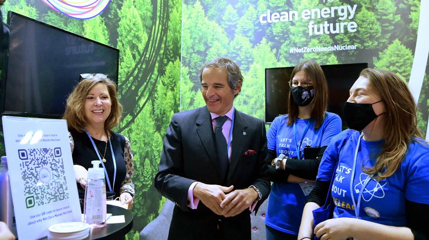 Grossi at a booth for clean energy surrounded by attendees