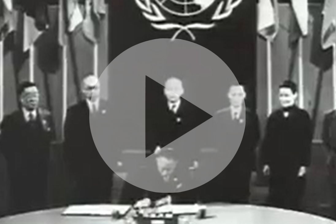 An image of a video of someone signing the UN Charter in 1945.
