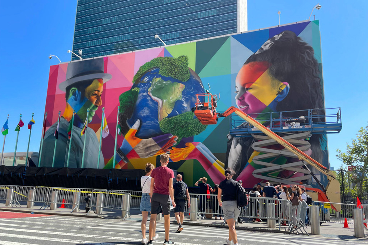 The mural outside UNHQ in New York with a girl in one side the earth in the middle and an old man in the other side