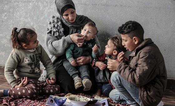 A Palestinian family  in Gaza share a meal bought with a WFP food voucher.