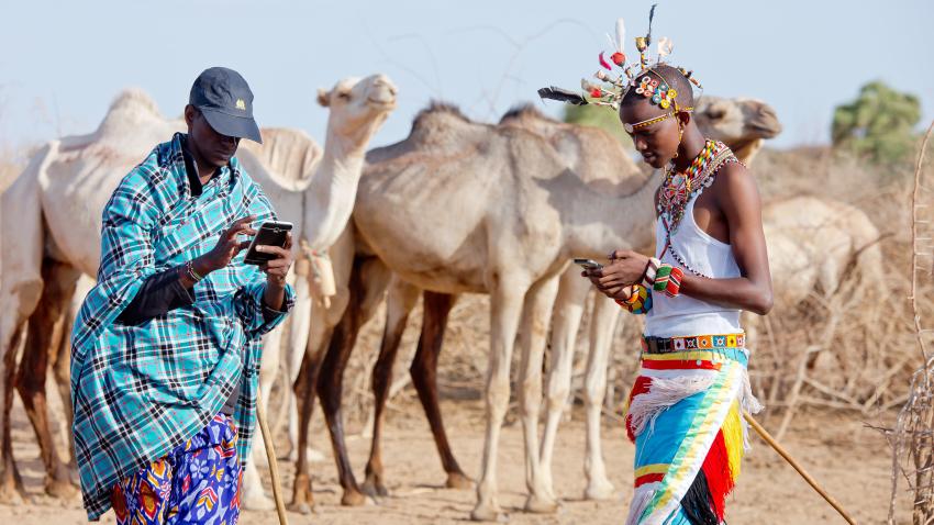 Kenyan pastoralists with cell phones using mobile app to beat the drought.