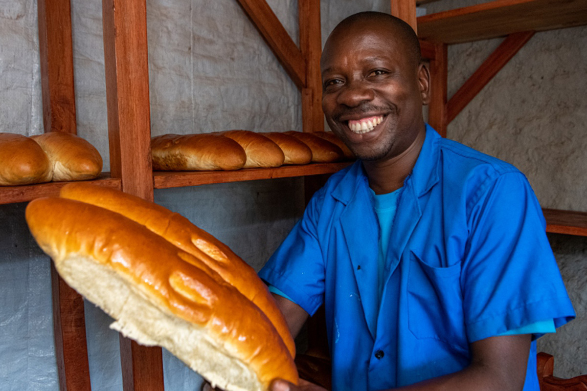 Cadet Kavugwa, a baker and a refugee from DR Congo poses with his freshly baked bread