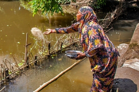 Woman in Bangladesh next to river.