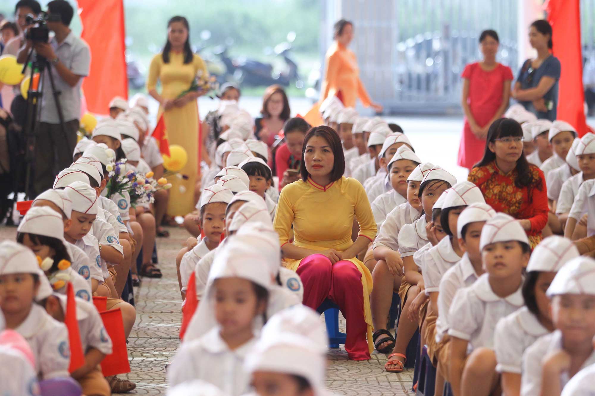 School children in uniforms assemble with their teachers