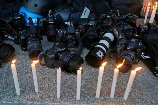 Cameras on the floor with lit candles in front of them. 