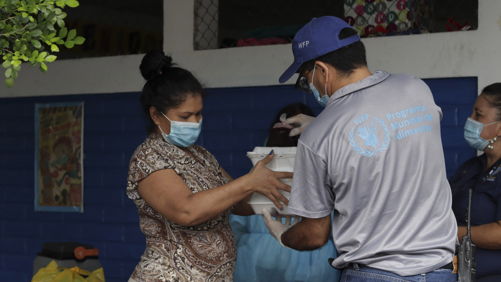 A World Food Programme staff member handing food to a woman in El Salvador.