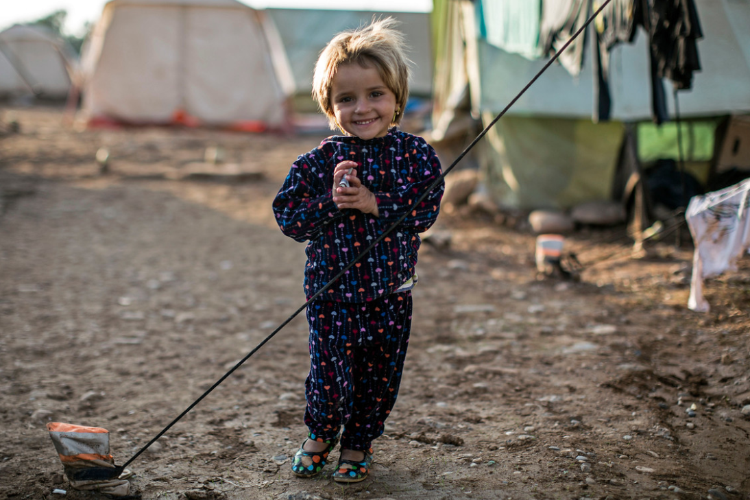 a young girl stands by her tent.